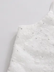Detailed macro view of white lace fabric with sparkling silver rhinestone embellishments
