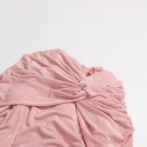 Detailed close-up of pink twisted shawl collar dress showing soft fabric texture