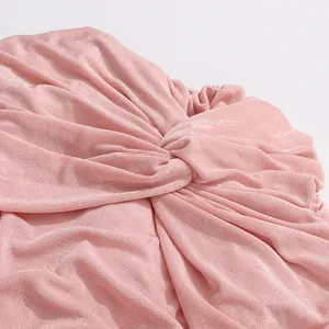 Detailed close-up of the elegant pink twist-knot design on a stretchy retro dress fabric.