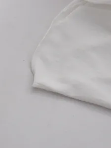 Close-up detail showing the neat stitching and soft fabric hem of the white French dress.
