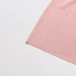 Detailed macro view showing the soft pink ribbed knit fabric texture of the elegant slim dress