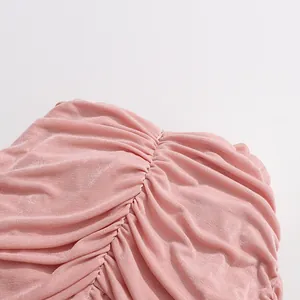 Close-up detail of soft pink ruched fabric texture on an elegant vintage dress.