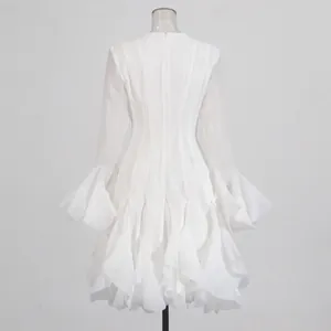 Achteraanzicht van een elegante witte jurk met klokmouwen en vele gelaagde ruches.
