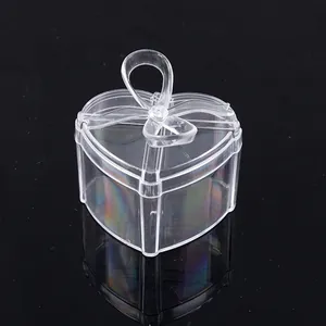 Detailed view of a transparent heart-shaped candy box with a decorative bow on top.