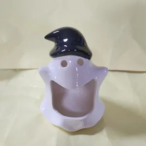 Detailed macro view of a cute white ceramic ghost with a black hat and open mouth design.