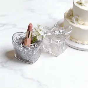 Detailed view of clear heart-shaped wedding favor box with decorative ribbon bow lid