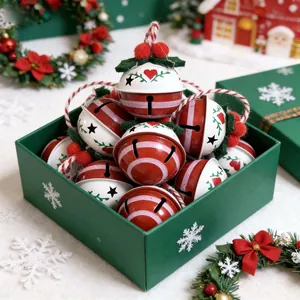 Rote und weiße Weihnachtsglocken aus Eisen in einer grünen festlichen Geschenkbox