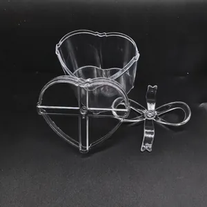 Detail shot of a clear heart-shaped plastic gift box featuring a lid and bow tie