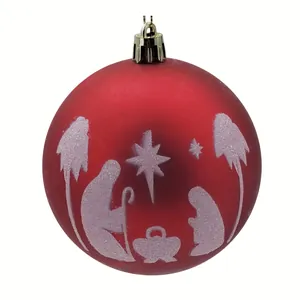 Detalle de pintura blanca del portal de Belén en una bola roja de Navidad brillante