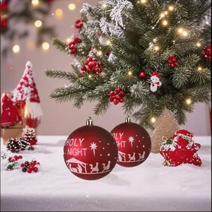 Detalle de bolas de Navidad rojas con estampado Holy Night sobre un fondo de nieve blanca