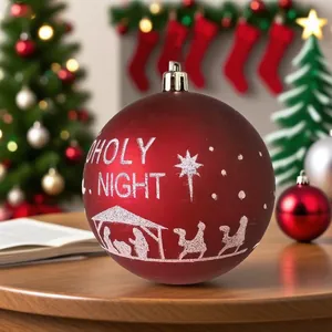 Primer plano de una bola de Navidad roja con un diseño blanco del portal de Belén
