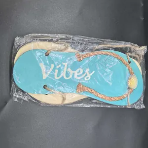 Detailed view of ocean-themed wooden flip-flop ornament in plastic packaging.