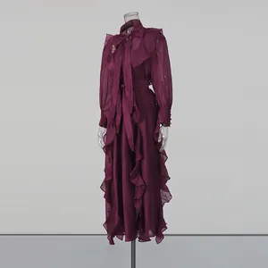 Elegant burgundy chiffon maxi dress with ruffle trim and neck tie detail on mannequin.
