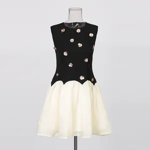 Detail view of retro sleeveless dress featuring metallic flowers and white tulle skirt