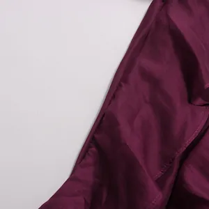 Close-up detail view of ruffled dark purple chiffon dress fabric texture and stitching