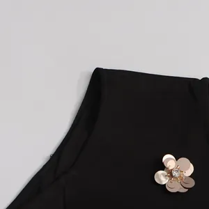 Detail of metallic sequin flower embellishment on black round neck sleeveless dress
