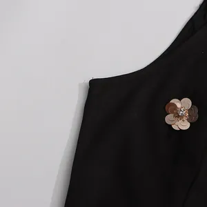 Close-up detail of metallic flower with sequins on a black vintage sleeveless dress