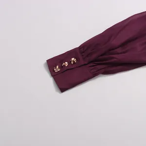 Detailed macro view of elegant purple chiffon dress cuff with gold metal buttons