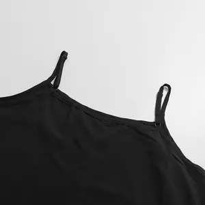 Gros plan des bretelles réglables sur une robe noire de style rétro français épuré.