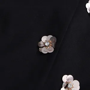 Close-up of sparkling sequined flower detail on elegant black French style dress