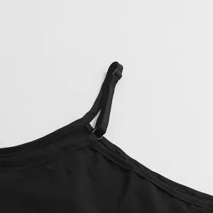 Détail montrant la bretelle réglable et les coutures d'une robe noire rétro française