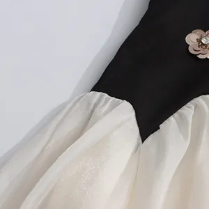Macro view of metallic flower accent and shimmering pleated fabric on a vintage dress