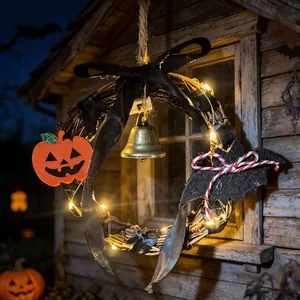 Beleuchteter Halloween-Rebenkranz mit Glocke, Kürbis und Fledermaus vor Holzwand.