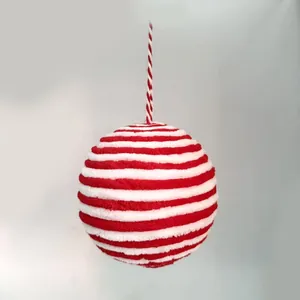 Close-up of red and white striped plush Christmas ball ornament with hanging string