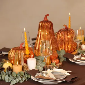 Cozy Thanksgiving table setting with illuminated glass pumpkin lights and candles