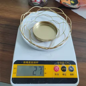 Dettaglio ravvicinato che mostra il peso di 27g di un portacandele decorativo in filo di ferro