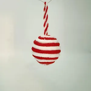 Detail of a red and white striped plush Christmas ball ornament with hanging rope