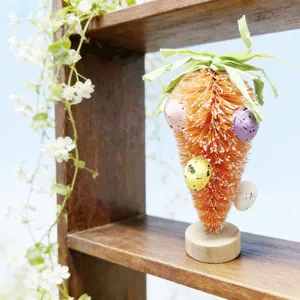 Décoration de Pâques avec carotte en sisal orange, œufs mouchetés et socle en bois