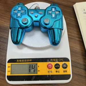 Addobbo natalizio a forma di controller blu che pesa 14 grammi su una bilancia