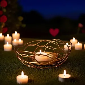 Elegante portacandele in filo d'oro intrecciato su prato con calde candele tea light
