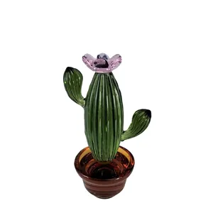 Vista detallada de un cactus de vidrio verde soplado a mano con flor rosa en maceta marrón