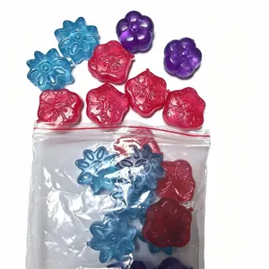 Detail view of colorful flower-shaped reusable plastic ice cubes in a clear resealable bag