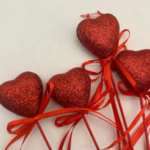 Detail shot of red glitter foam heart picks with elegant ribbon bows for Valentine's Day