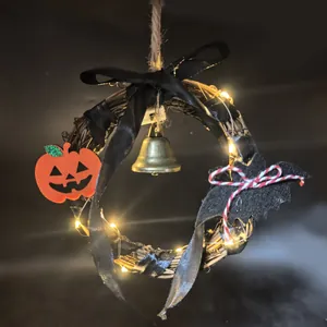 Detail eines Halloween-Rattankranzes mit LED-Lichtern, Kürbis- und Fledermausdeko.