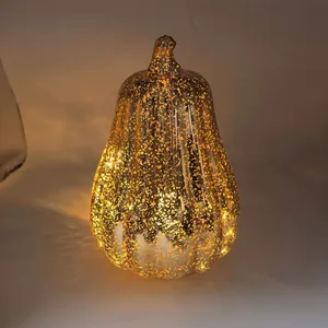 Detail view of a glowing gold mercury-glass pumpkin LED lamp for festive Halloween decor