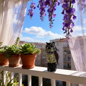 Realistischer Eulen-Lockvogel für den Gartenschutz auf einem sonnigen Balkongeländer