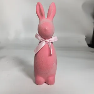 Close-up view of a decorative pink flocked Easter bunny figurine with a pink satin bow.