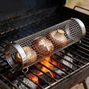 Rolling stainless steel BBQ grill basket containing mushrooms over burning coals.