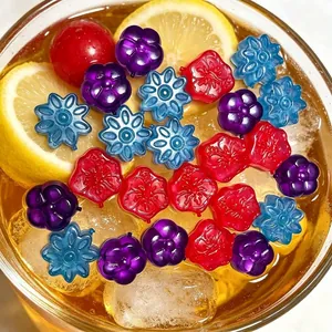 Detail of colorful flower-shaped reusable plastic ice cubes in a cold summer drink.