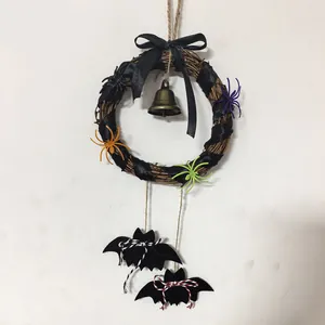 Halloween-Rebenkranz mit Glocke, bunten Spinnen und hängenden schwarzen Filzfledermäusen.