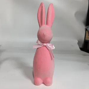 Detailed view of a cute pink flocked Easter bunny figurine with a decorative pink bow