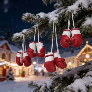Mini guantoni da boxe rossi festivi appesi a un ramo di un albero di Natale innevato