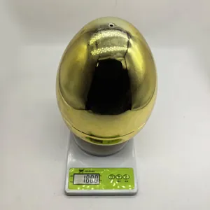 Dettaglio di un grande uovo di plastica dorata galvanica su una bilancia da 180 grammi