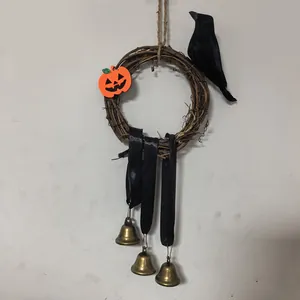 Detail eines Halloween-Rebenkranzes mit Kürbis, Krähe und hängenden Messingglocken