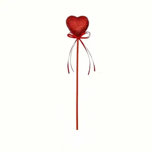 Detailed view of red glitter foam heart pick with ribbon bow for Valentine's Day decor.