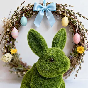 Detail view of a green flocked Easter rabbit figurine with a decorative willow wreath